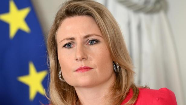 Österreichs Integrationsministerin Susanne Raab mit ernstem Gesichtsausdruck vor Europaflagge