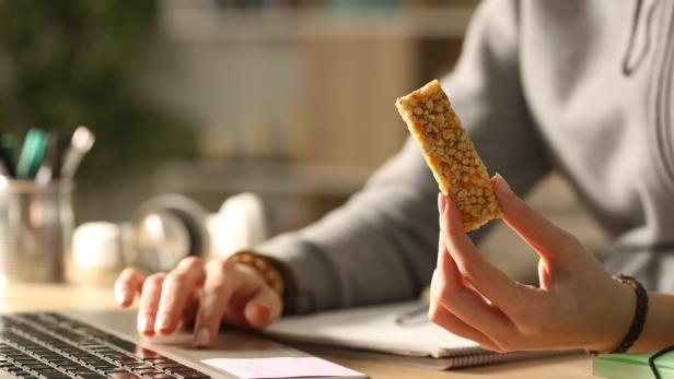 Eine Frau snackt beim Arbeiten