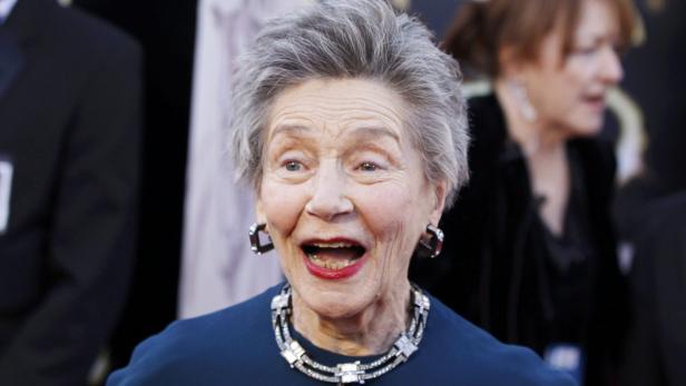 Nahaufnahme von Olympia Dukakis mit offenem Mund und auffälligem Schmuck.