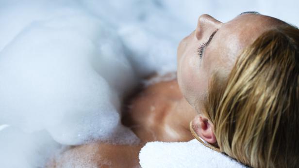 Eine Frau entspannt in einem Schaumbad.