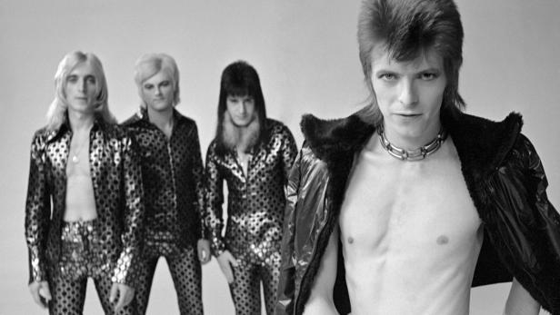 David Bowie und seine Band in glitzernden Outfits während seiner Ziggy Stardust-Ära.
