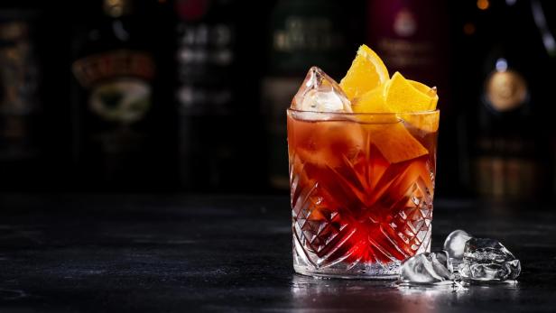 Negroni-Cocktail mit Eis und Orangenscheiben in einem Kristallglas.