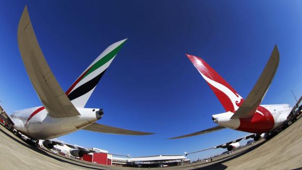 Emirates and Qantas A380 aircraft sit on the tarmac at Kingsford Smith international airport in Sydney in this September 6, 2012 file photo. Australia&#039;s competition regulator granted conditional final approval on March 27, 2013 to a five-year alliance between struggling national flag carrier Qantas Airways Ltd and Emirates Airline, just days before the first Qantas flight is due to transit through Dubai. REUTERS/Daniel Munoz/Files (AUSTRALIA - Tags: BUSINESS TRANSPORT)
