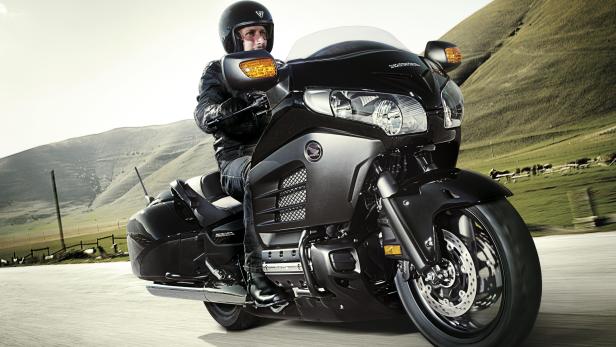 Ein Mann fährt mit einer Honda Gold Wing auf einer Landstraße.