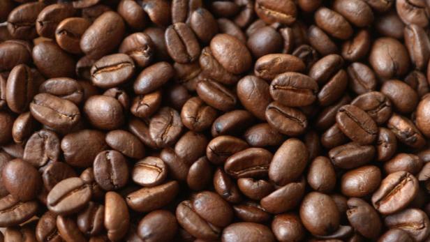 Nahaufnahme von vielen gerösteten Kaffeebohnen.