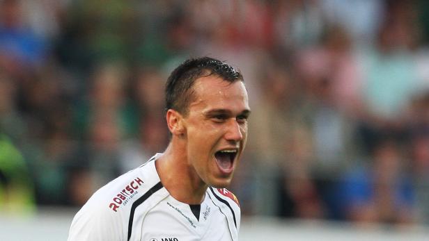Ein Fußballspieler schreit auf dem Spielfeld.