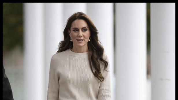 Prinzessin Kate geht mit einer Handtasche in der Hand.