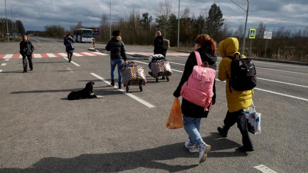 FILE PHOTO: Children taken to Russia walk to a bus after returning via the Ukraine-Belarus border, in Volyn region