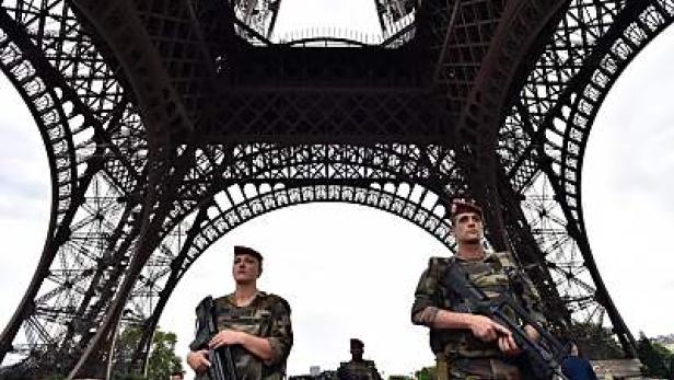 Soldaten patrouillieren vor dem Eiffelturm in Paris.