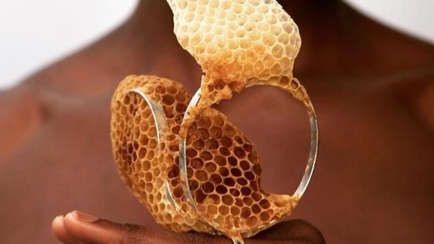 Ein Ring mit Honigwaben auf der Hand einer Person.