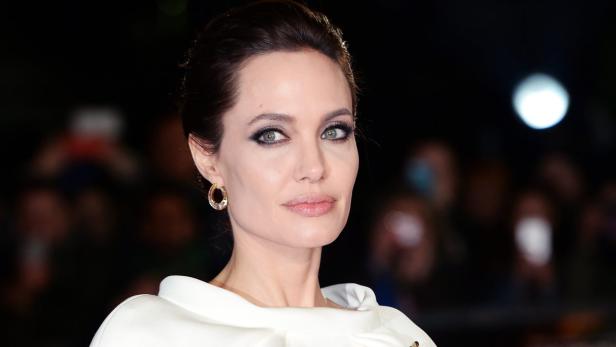 Ein Porträt von Angelina Jolie mit dezentem Make-up und goldenen Ohrringen.