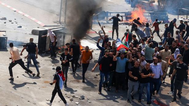 Proteste im Westjordanland. Die Menge trägt eine Leiche durch die Stadt
