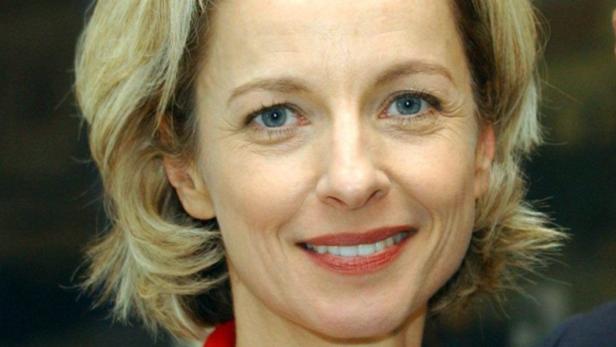 Nahaufnahme einer lächelnden Frau mit blonden Haaren und blauen Augen.