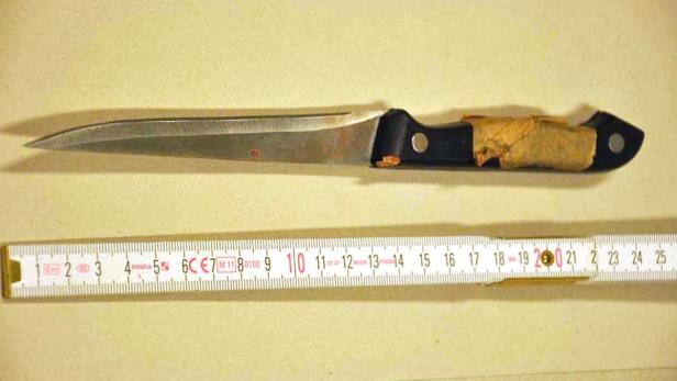 Ein Messer mit schwarzem Griff liegt neben einem Zollstock.