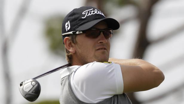 Ein Golfspieler mit Sonnenbrille schwingt seinen Schläger.