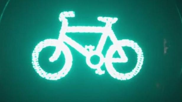 Ein leuchtendes Fahrradsymbol auf grünem Hintergrund.