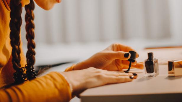 Frau, die sich für Halloween die Nägel lackiert.