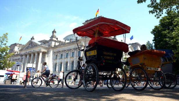 epa03803811 Rickshaws are parked in the shade in front of the Reichstag while temperatures reached 35 degrees Celsius in Berlin, Germany, 27 July 2013. Weather forecasts predict high temperatures with up to 40 degrees Celsius for eastern and southern parts of Germany for the coming days. EPA/RAINER JENSEN