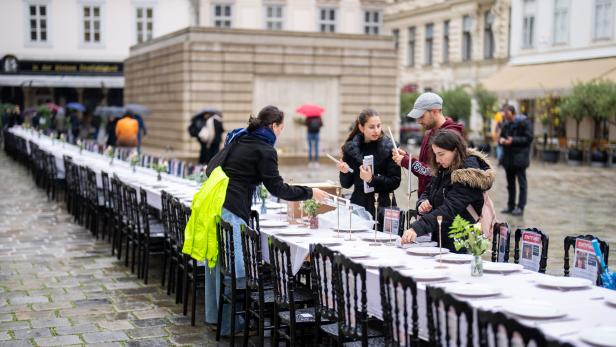 Menschen decken den leeren Schabbat-Tisch am Judenplatz in Wien