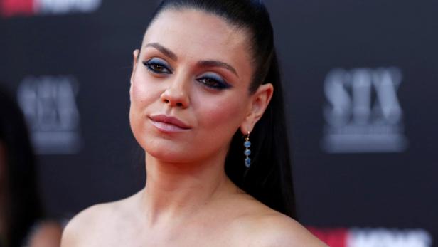 Mila Kunis mit blauem Lidschatten und Ohrringen.