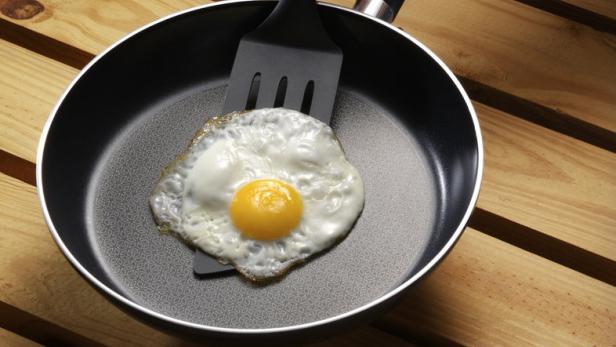 Ein Spiegelei wird mit einem Pfannenwender in einer Bratpfanne zubereitet.