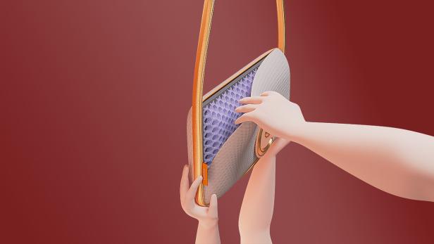 Eine Hand öffnet die „Emma The Pillow Bag“ und zeigt das Innenleben.