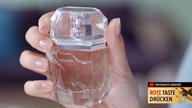 Eine Hand hält einen Flakon des Parfüms „Helene Fischer“.