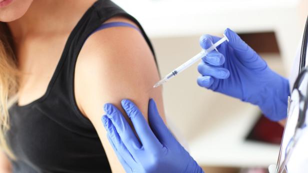 Young doctor giving a patient injection.