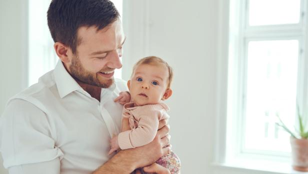 Vater posiert stolz mit Baby