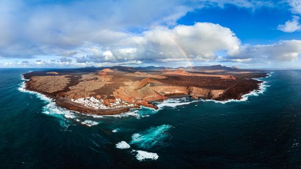 Luftaufnahme von El Golfo, Lanzarote, mit einem Regenbogen im Hintergrund.