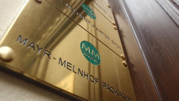 Eine goldene Plakette mit der Aufschrift Mayr-Melnhof Packaging neben einer Holztür.
