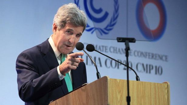 John Kerry spricht auf einer Klimakonferenz hinter einem Rednerpult.