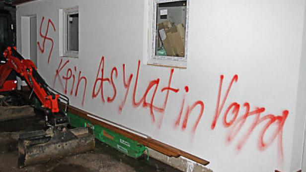 Eine Hauswand ist mit Hakenkreuzen und dem Schriftzug „Kein Asylatin Vora“ beschmiert.