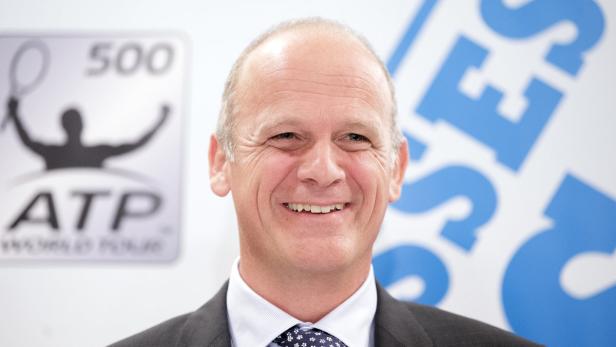 Ein lächelnder Mann im Anzug vor einem ATP-Logo.