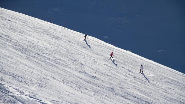 Skiers going down the slope at ski resort.
