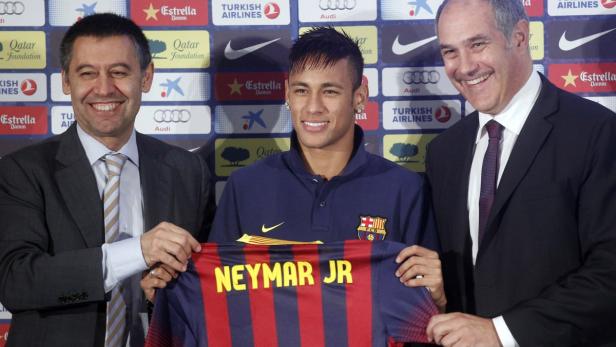 Brazilian soccer player Neymar (C) poses with his new jersey next to sports director Andoni Zubizarreta (R) and vice-president Ferran Bartomeu (L) after signing a five-year contract in Barcelona June 3, 2013. REUTERS/Albert Gea (SPAIN - Tags: SPORT SOCCER)