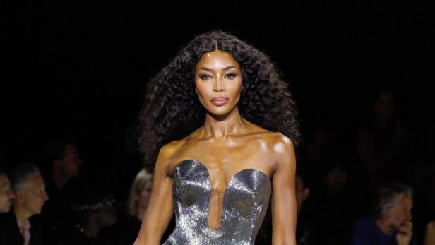 Naomi Campbell läuft in einem silbernen Kleid über den Laufsteg.