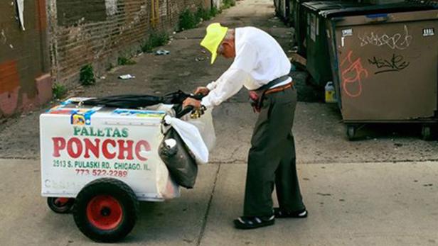 Ein Mann mit gelbem Hut verkauft Paletas Ponche Eis in Chicago.
