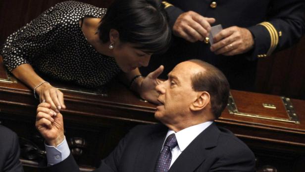 Italy&#039;s Prime Minister Silvio Berlusconi (R) talks with Minister of Equal Opportunities Mara Carfagna during a debate at Italy&#039;s upper house of Parliament in Rome July 29, 2010. REUTERS/Alessandro Bianchi (ITALY - Tags: POLITICS)
