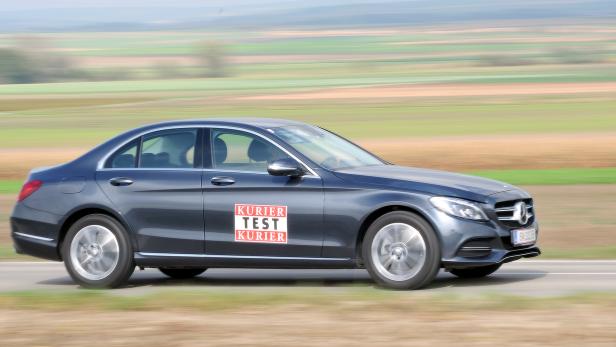 Ein grauer Mercedes-Benz mit „Kurier Test“-Aufkleber fährt auf einer Landstraße.