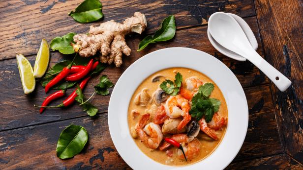 Eine asiatische Suppe mit Garnelen, Pilzen und Ingwer wird serviert.