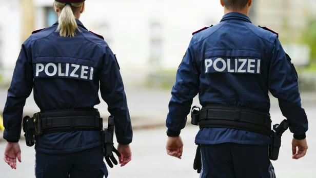 Zwei Polizisten gehen nebeneinander.