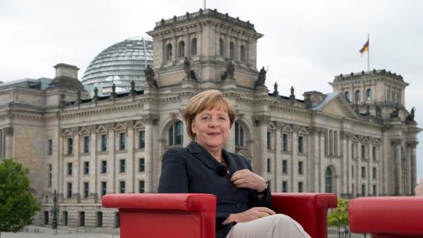 epa03788007 German Chancellor Angela Merkel sits in front of the Reichstag building after arriving for the German public broadcaster ARD&#039;s annual summer interview in Berlin, Germany, 14 July 2013. EPA/SOEREN STACHE