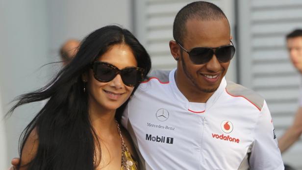 McLaren Formula One driver Hamilton walks with his