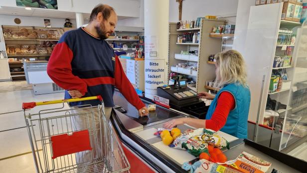 Mann an der Supermarktkasse