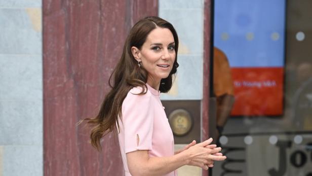 Prinzessin Kate in einem rosa Kleid und weißen Schuhen.