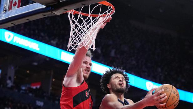 Ein Basketballspieler versucht, den Ball am Korb vorbei zu werfen.