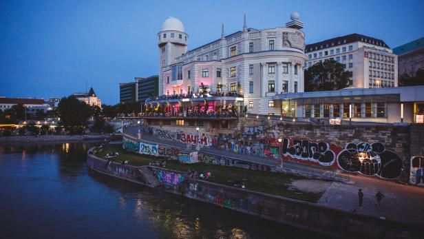 Die Wiener Urania und der Donaukanal bei Dämmerung.
