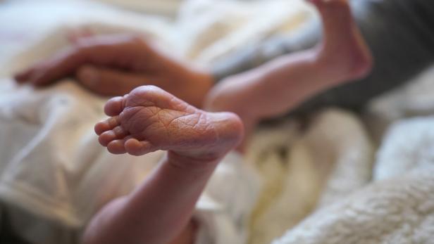 Ein Neugeborenes streckt seinen Fuß in die Höhe.