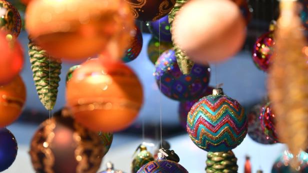Verschiedenfarbige Weihnachtskugeln und Tannenzapfen hängen von der Decke.